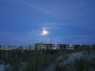 The full moon above the condominiums -- somewhat obscured by clouds.