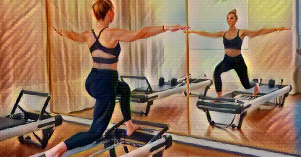 woman does a lunge on a Pilates reformer machine, arms extended out from her side. She is wearing a black sports bra and spandex pants and appears fit and trim.