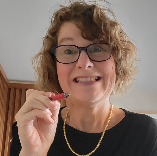 a woman holding a red pen -- as if she were going to edit something or issue her grade -- grins somewhat mischievously. No fear, it's just Sara Dagen, the author of All Things Work Together.